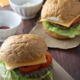 Banana Heart Burgers with lettuce, tomato, and cheese on a wooden board