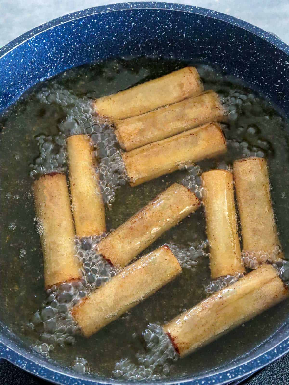 deep-frying spring rolls in a pot