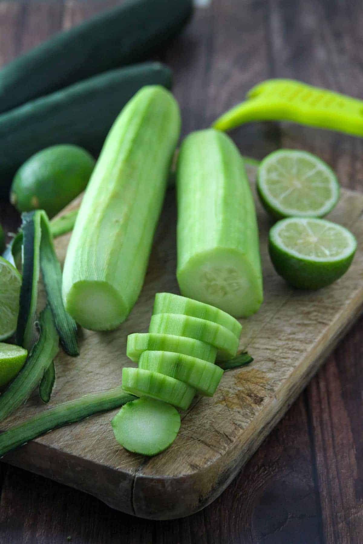 peeled and sliced cucumbers on a cutting board