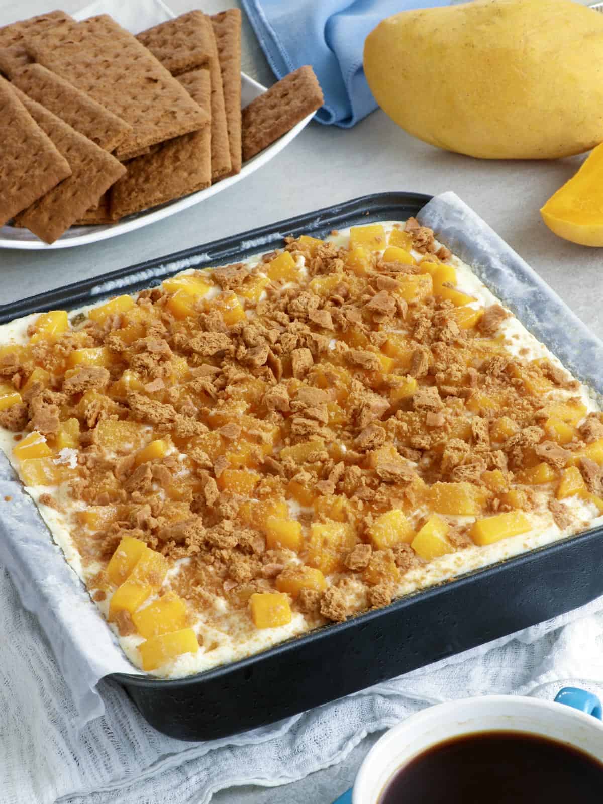 mango float with crush graham crackers in a square pan