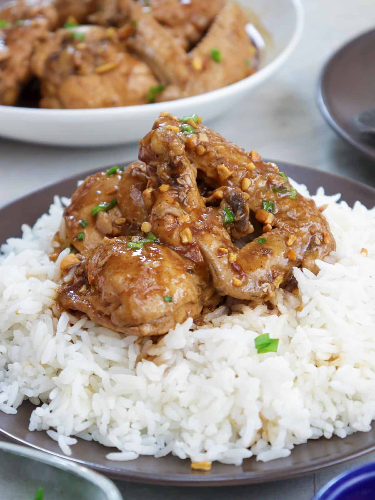 adobong manok sa sampalok with steamed rice on a plate