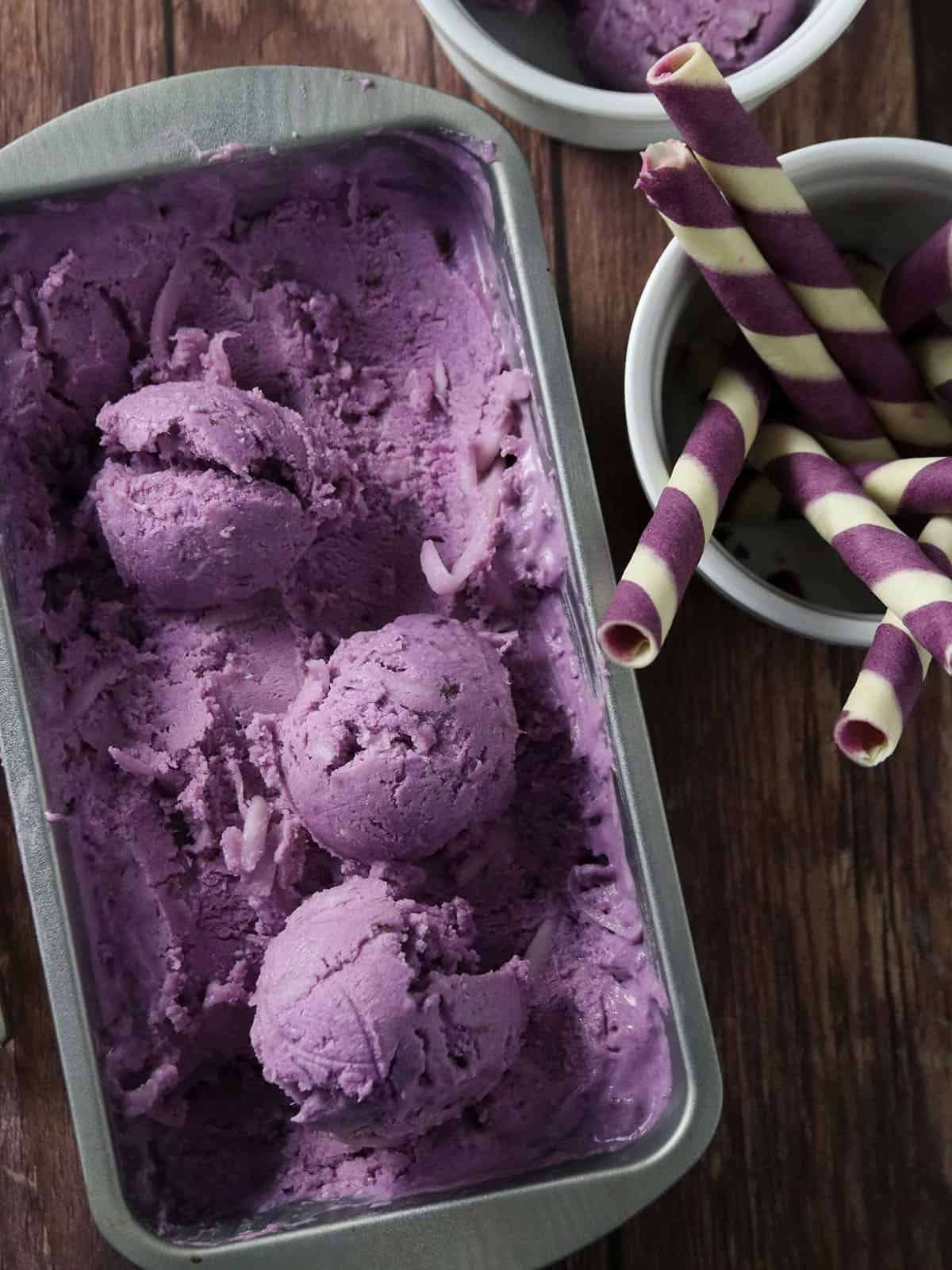 ice cream scoops in a metal tin with cookie wafers on the side