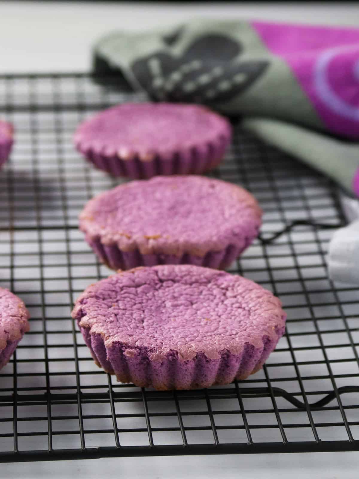 mamon sponge cakes with ube flavor on a baking rack