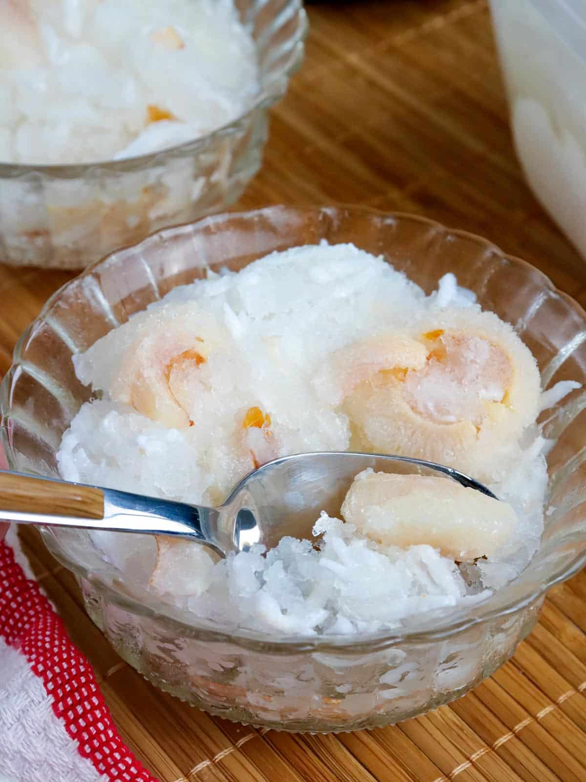 eating Buko Lychee Sorbet in a bowl with a spoon.