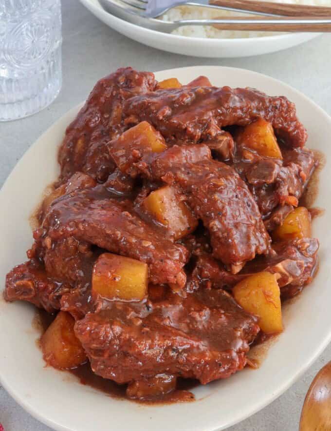 braised spare ribs with pineapples on a white platter.