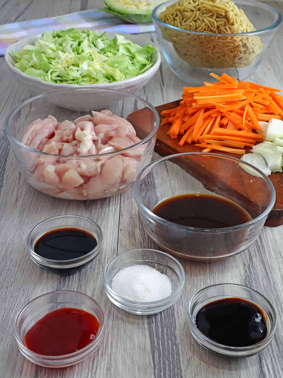 egg noodles, diced chicken breasts, julienned carrots, shredded cabbage, sauces in bowls