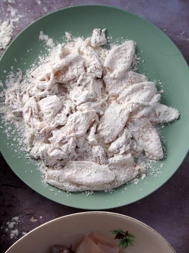 coating soaked squid in flour mixture