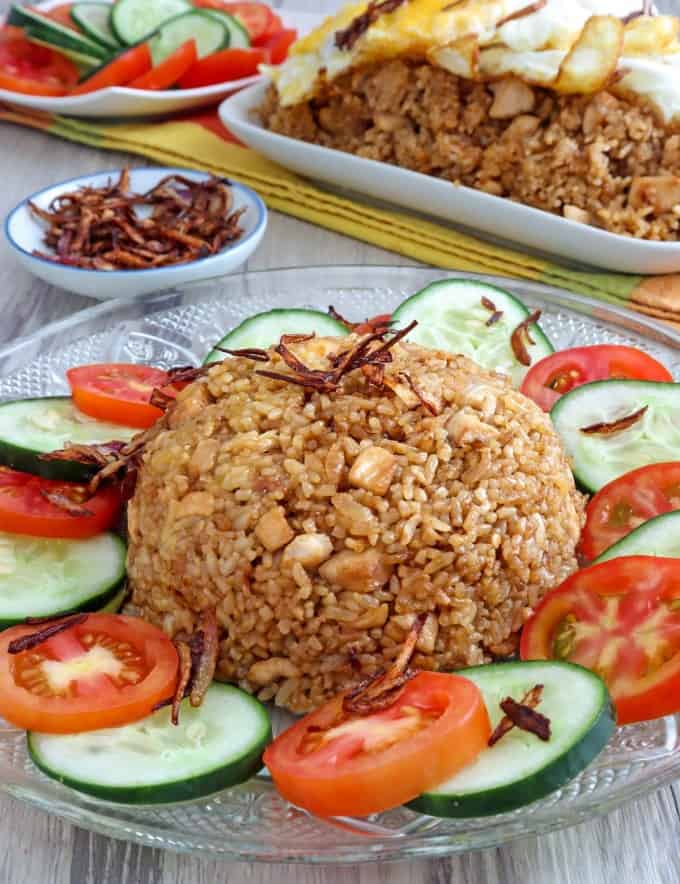 Nasi Goreng on a plate garnished with sliced tomatoes and cucumber