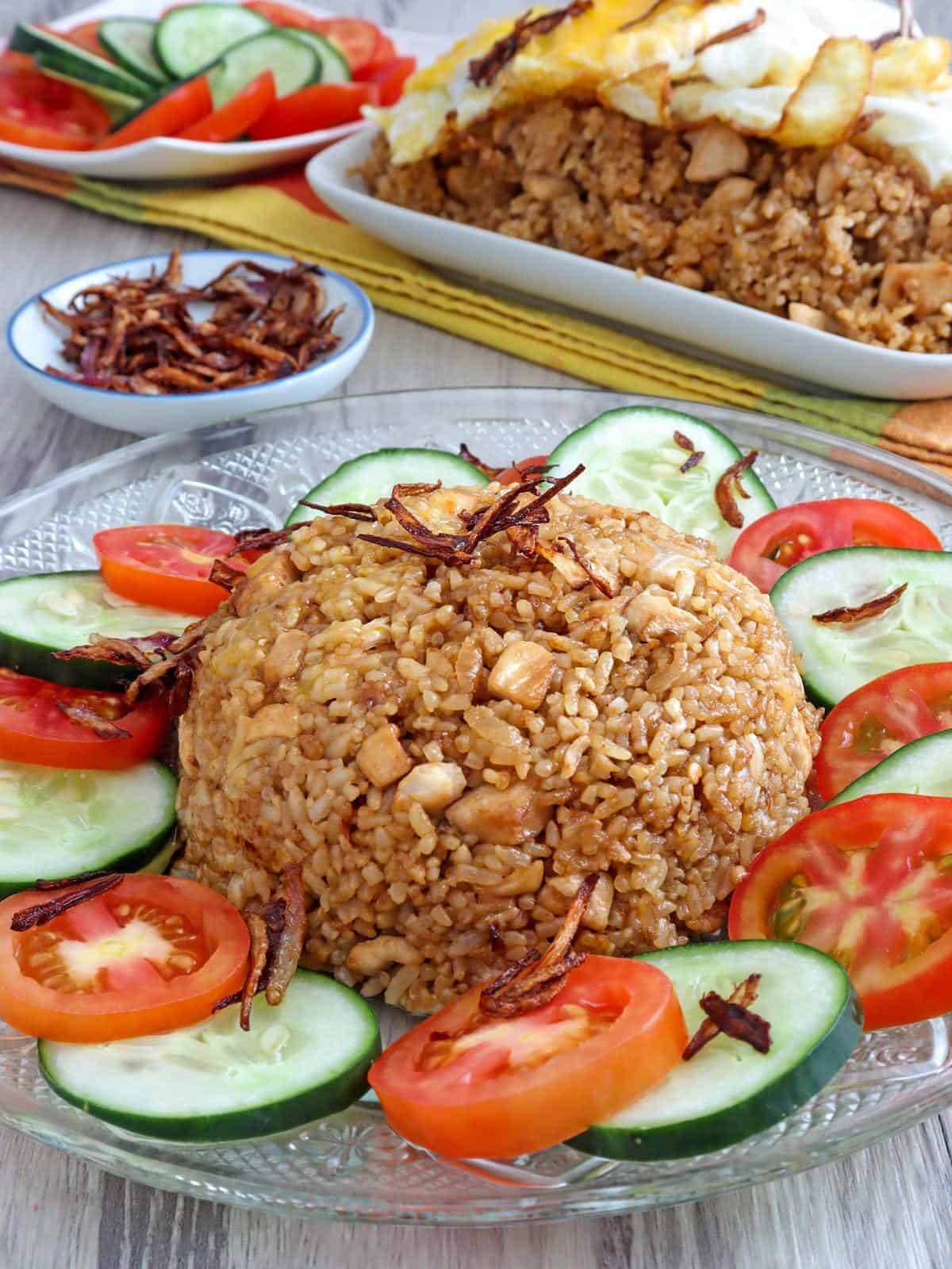 Nasi Goreng on a plate garnished with sliced tomatoes and cucumber