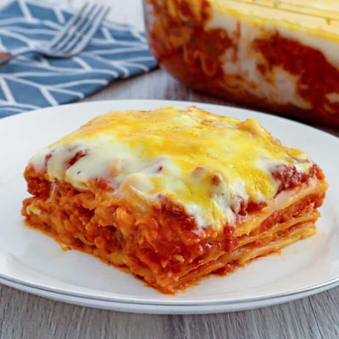 Cheesy lasagna with bechamel sauce layers from a baking dish with a spatula