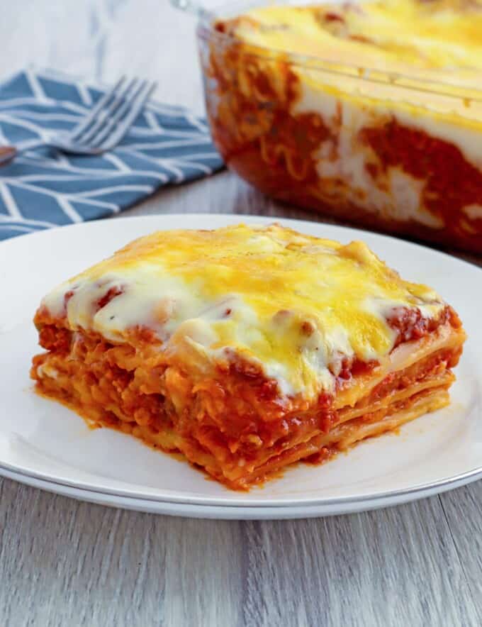 Cheesy lasagna with bechamel sauce layers from a baking dish with a spatula