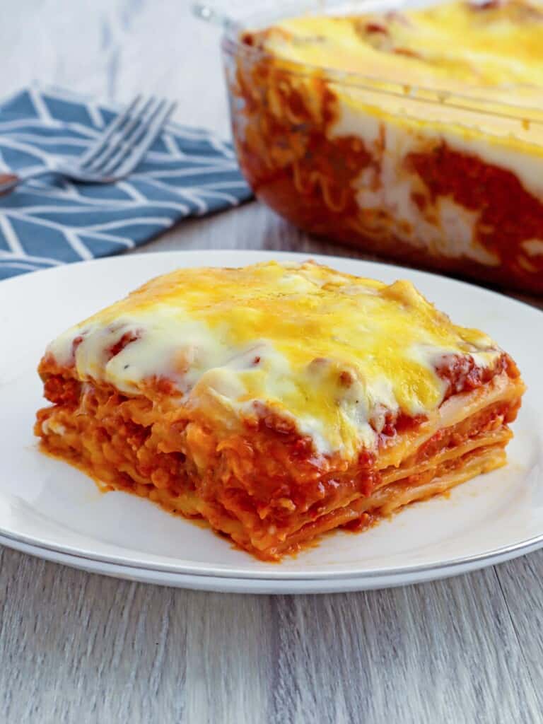 Cheesy lasagna with bechamel sauce layers from a baking dish with a spatula