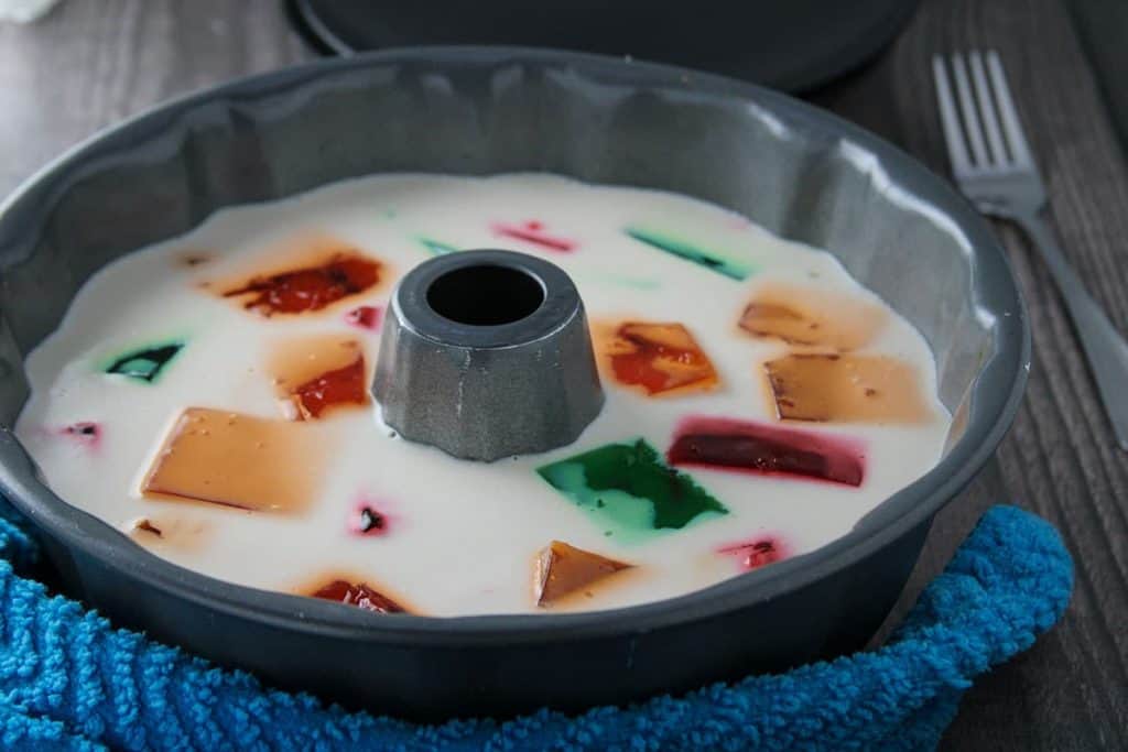 cream-flavored gelatin with colored gelating cubes in a bundt pan