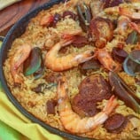 Paella with shrimp, chicken, mussels in a wide pan