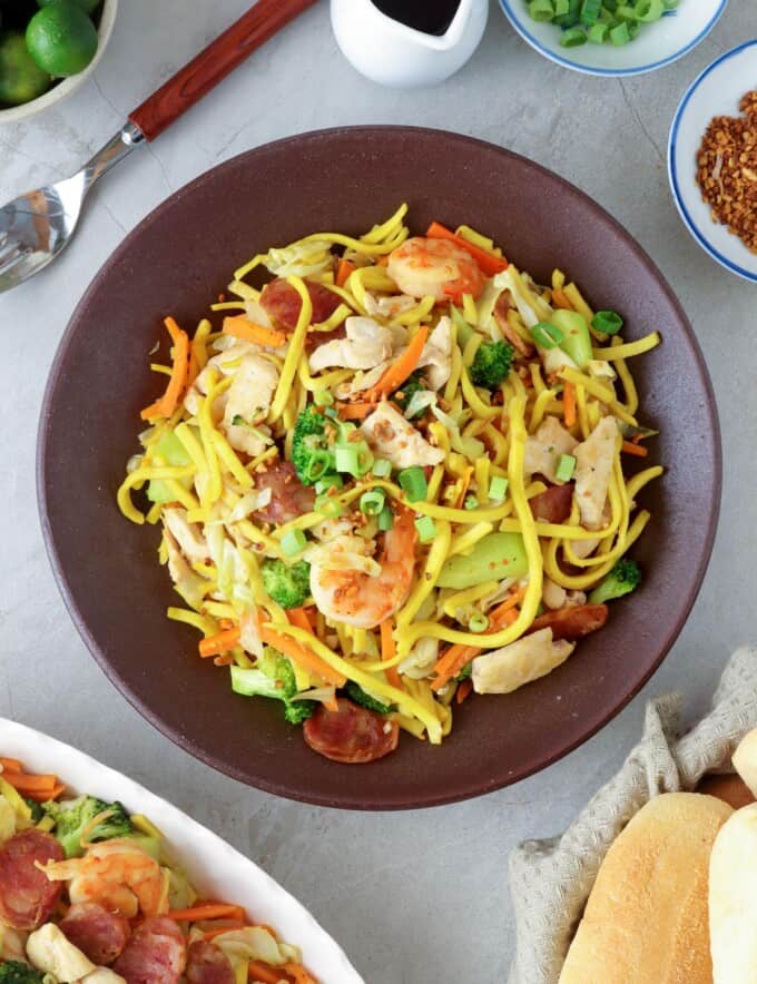 Pancit Lomi Guisado on a serving plate with pandesal on the side