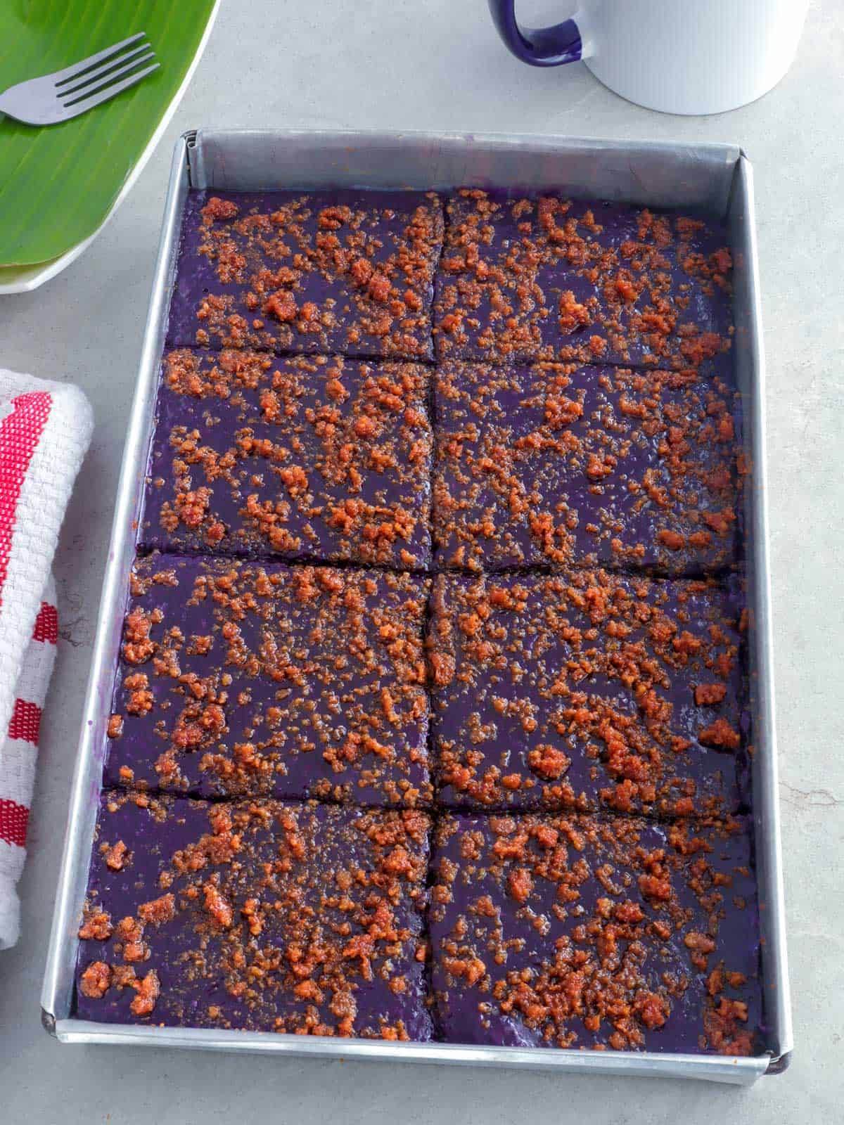 Ube Kalamay with latik topping in an aluminum pan