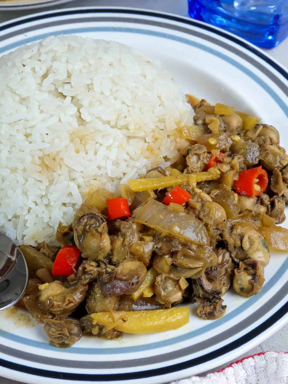 oysters adobo on a serving plate with steamed rice