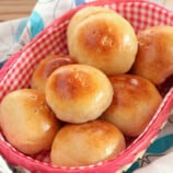 Pan de Coco bread rolls in a checkered bread basket