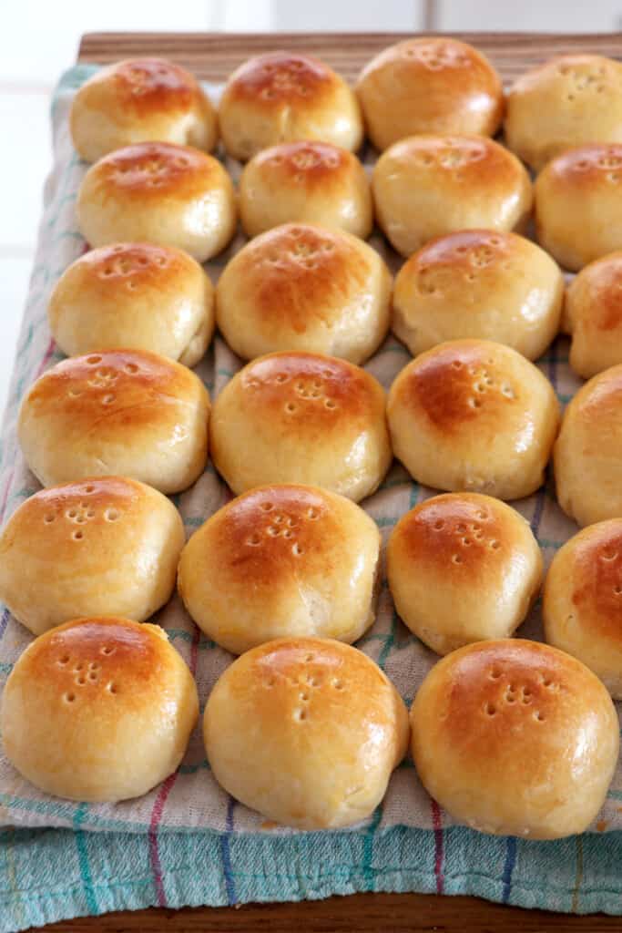 Freshly baked pan de coco on a baking sheet.