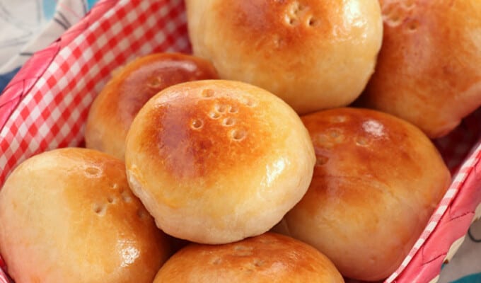 Pan de Coco bread rolls in a checkered bread basket