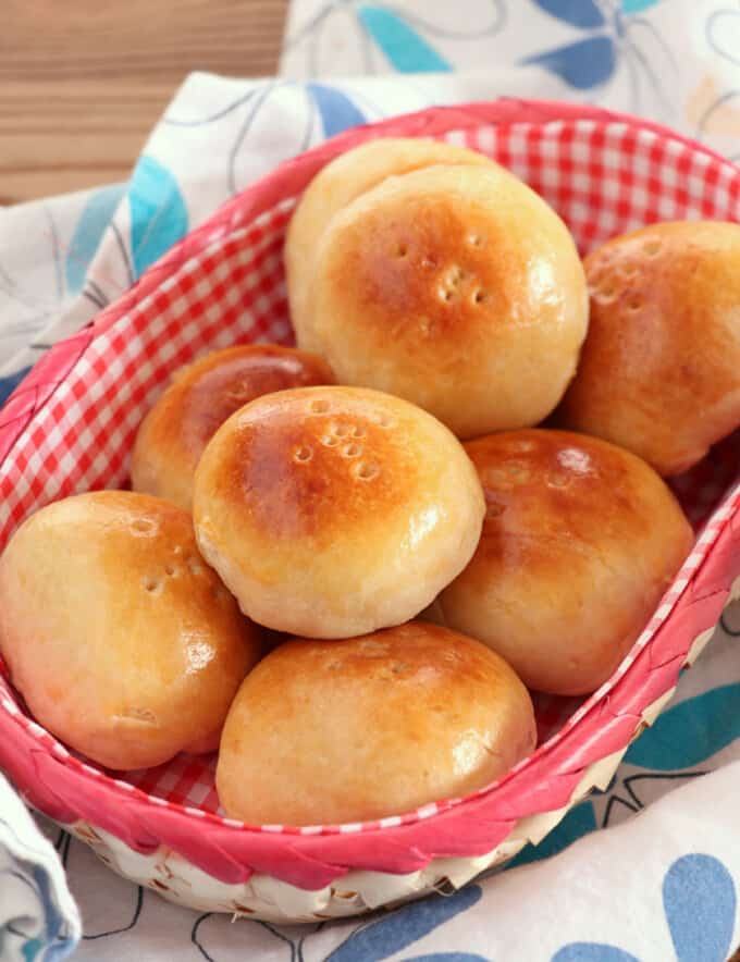 Pan de Coco bread rolls in a checkered bread basket