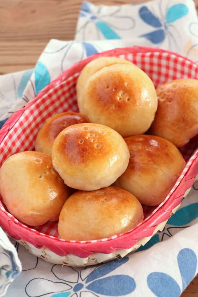 Pan de Coco bread rolls in a checkered bread basket
