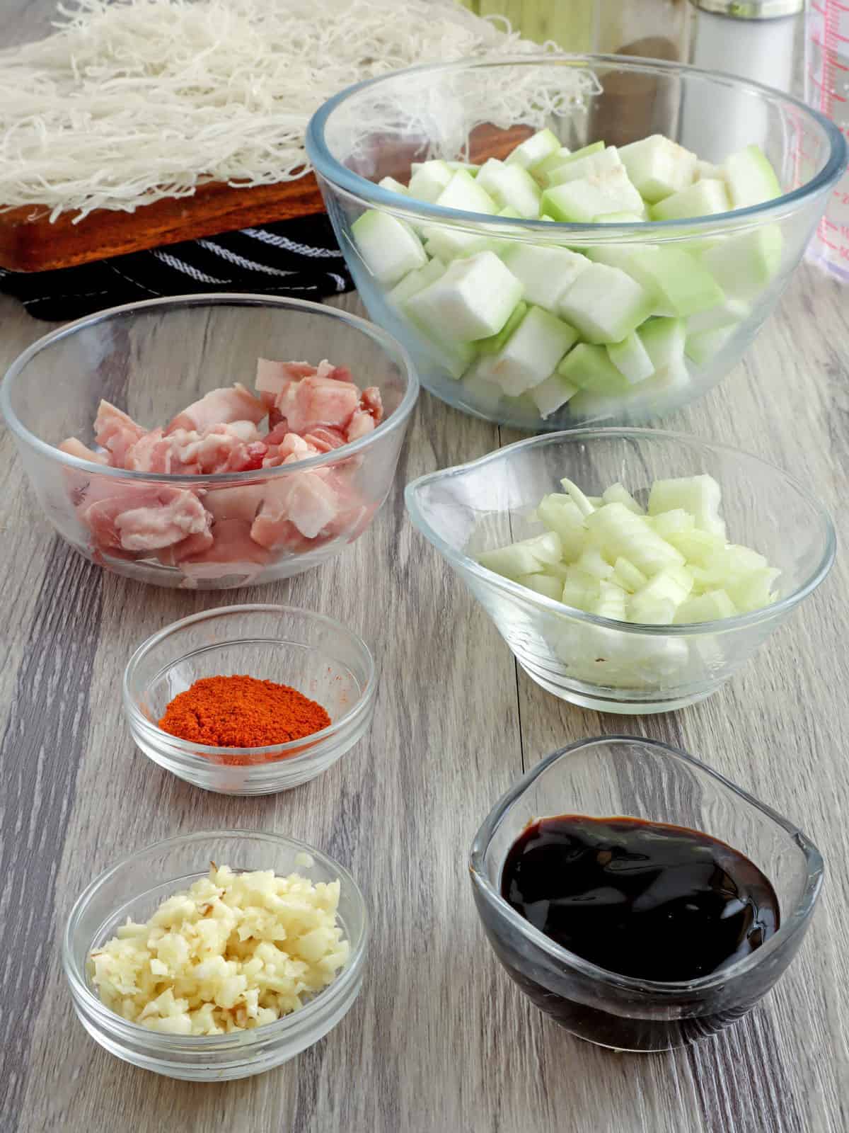 chopped onions, garlic, diced upo, dry bihon, diced pork belly, oyster sauce, annatto powder in inidividual bowls