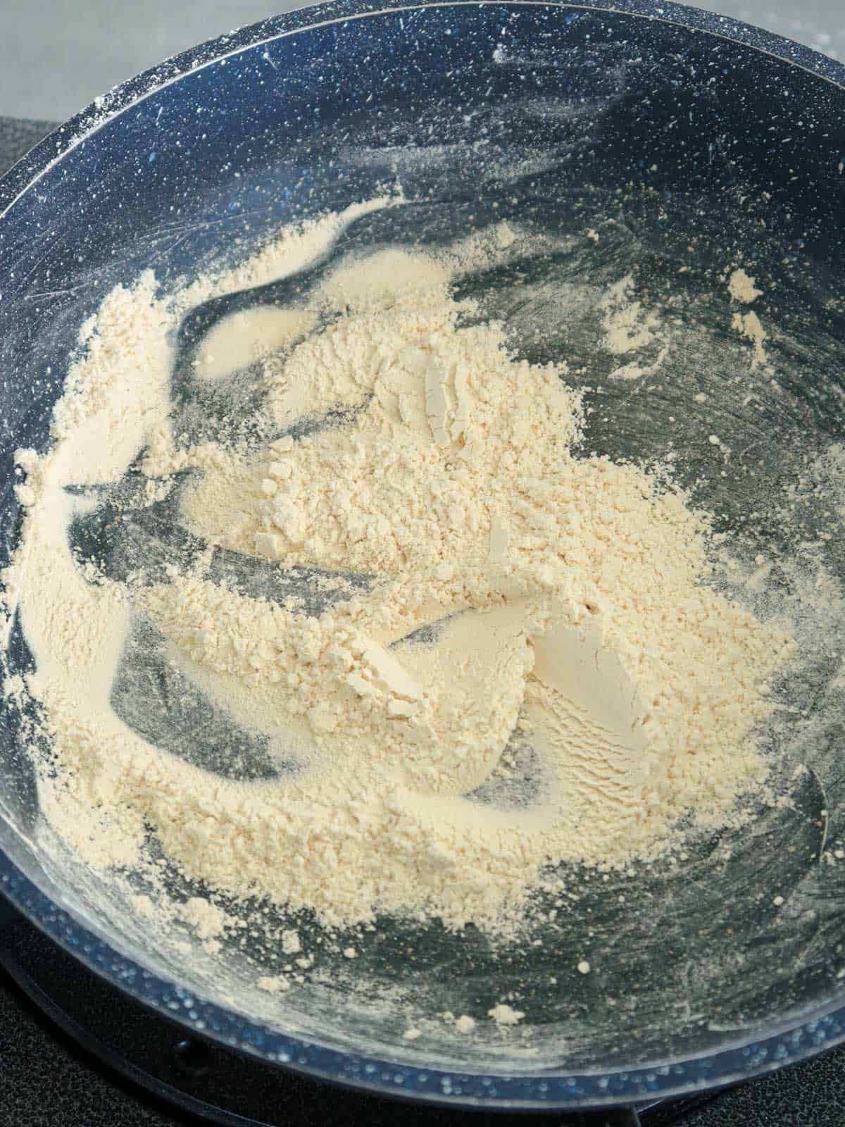 toasting rice flour in a pan.