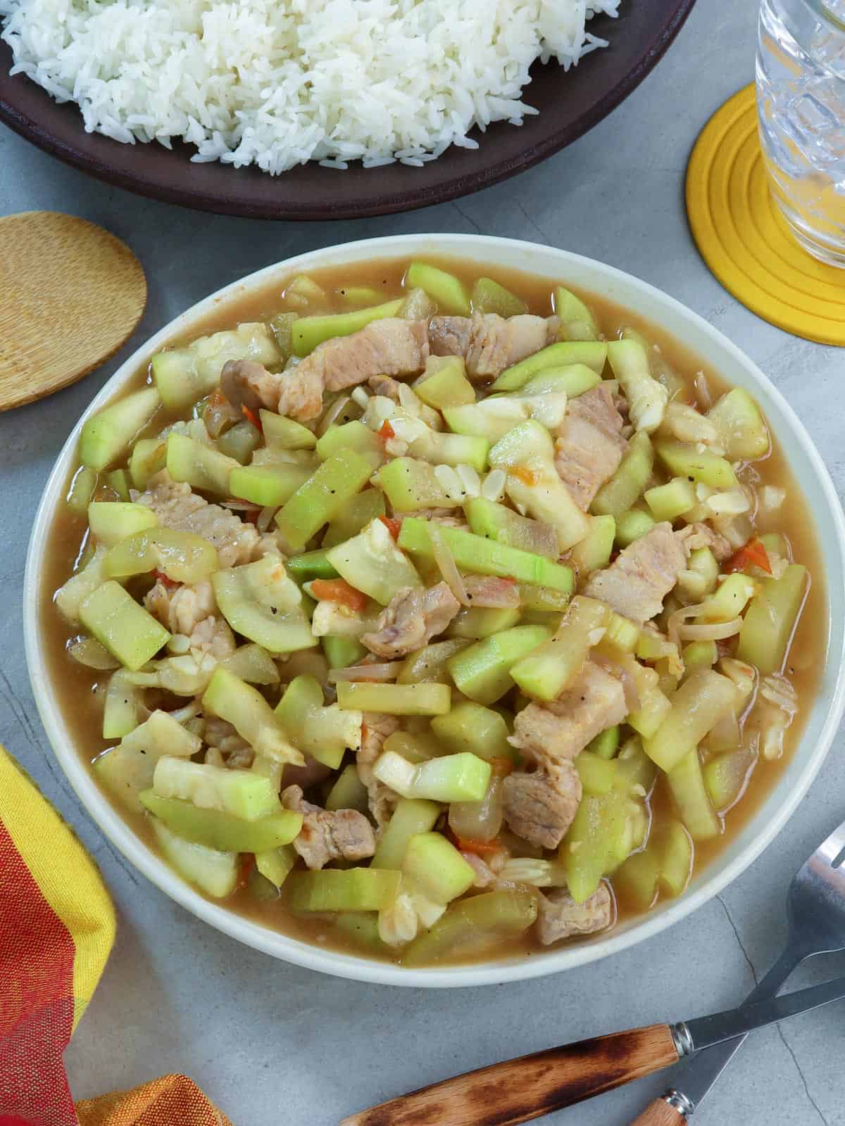 Ginisang Upo with Pork in a white serving bowl with a side of steamed rice