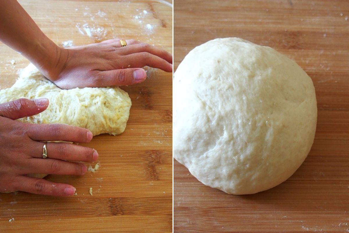 kneading bread dough with hands on a floured wood board