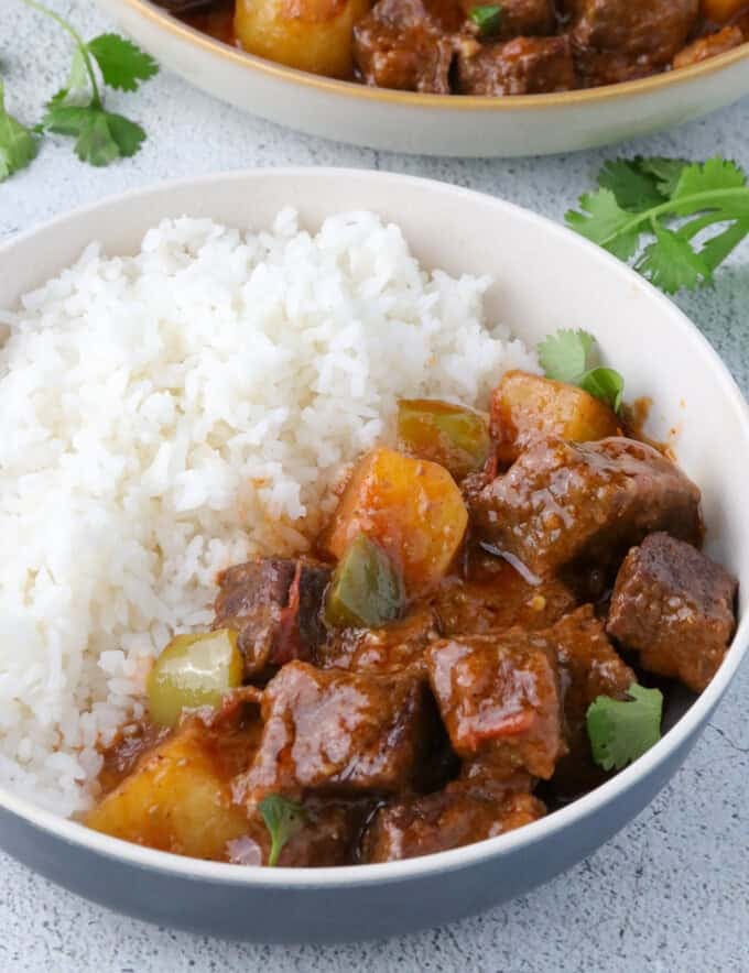 Carne Guisada with steamed rice in a bowl.