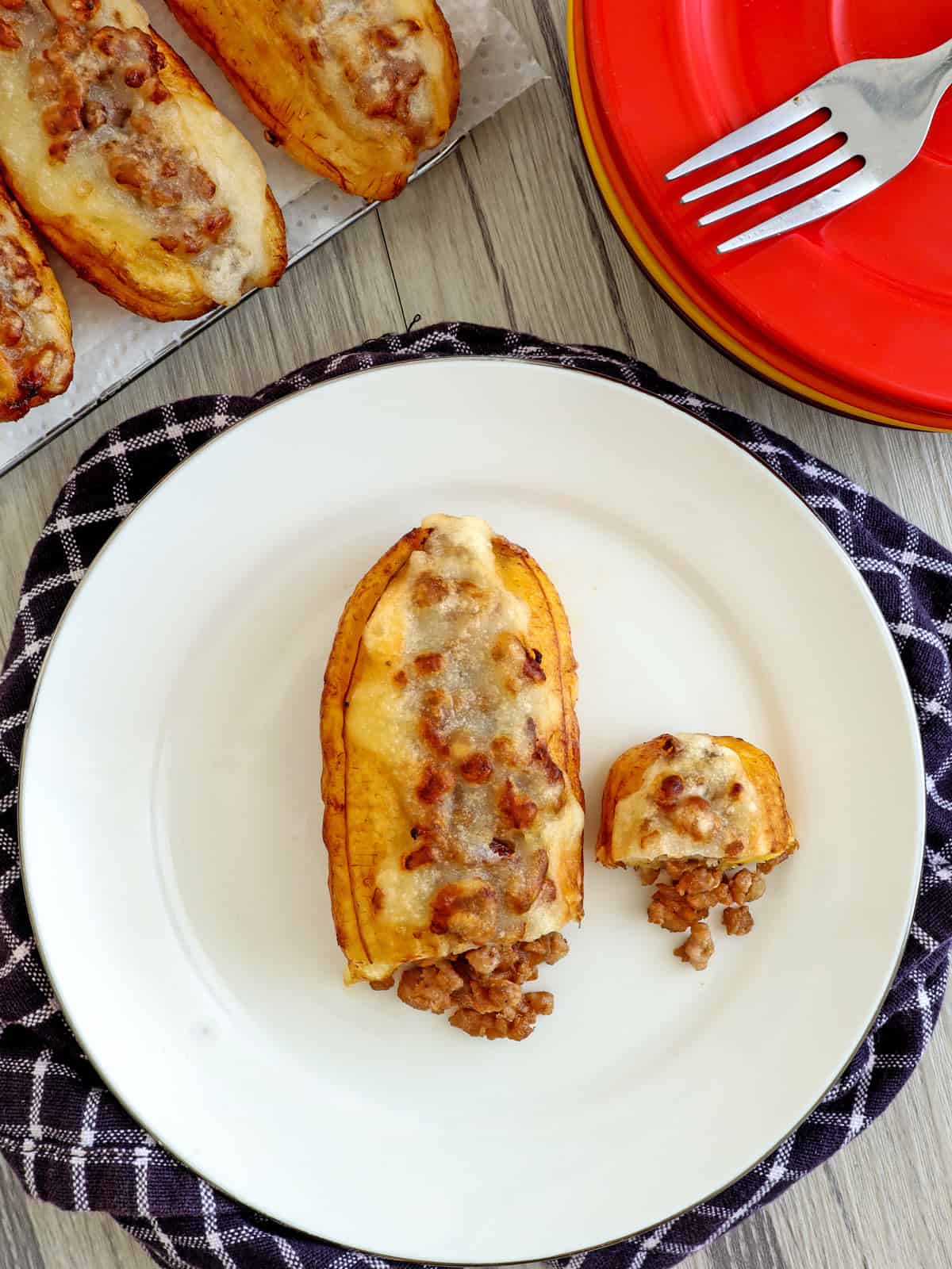 saba bananas stuffed with ground pork and fried until golden on a white plate