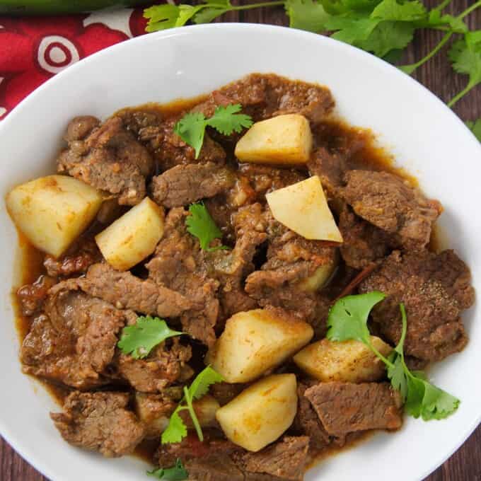 Mexican-style braised beef and potatoes in tomato sauce stew in a serving bowl