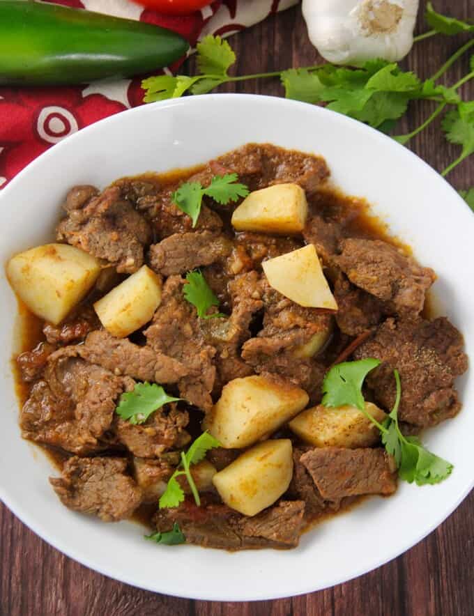 Mexican-style braised beef and potatoes in tomato sauce stew in a serving bowl