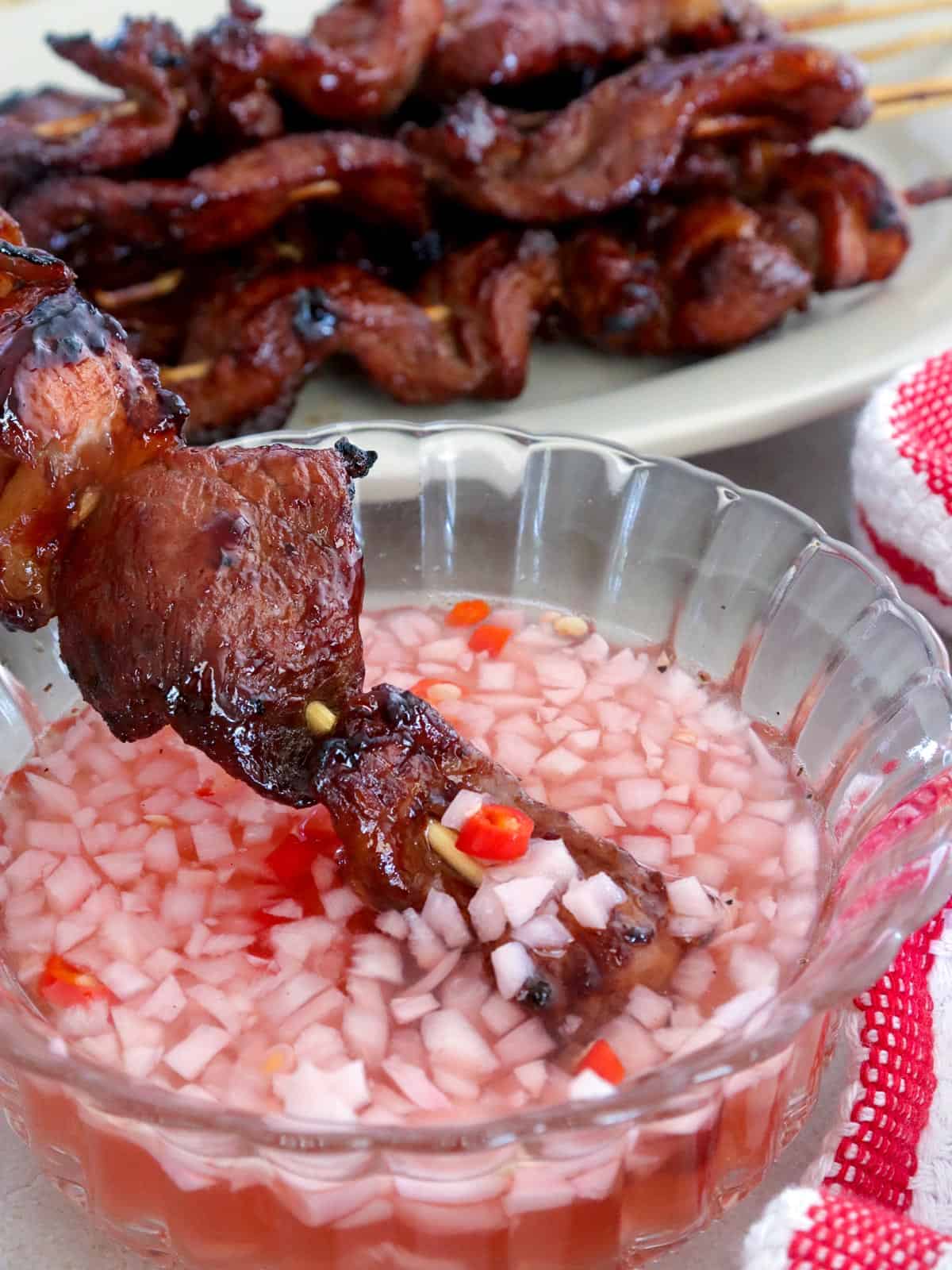 dipping pork barbecue in spicy vinegar