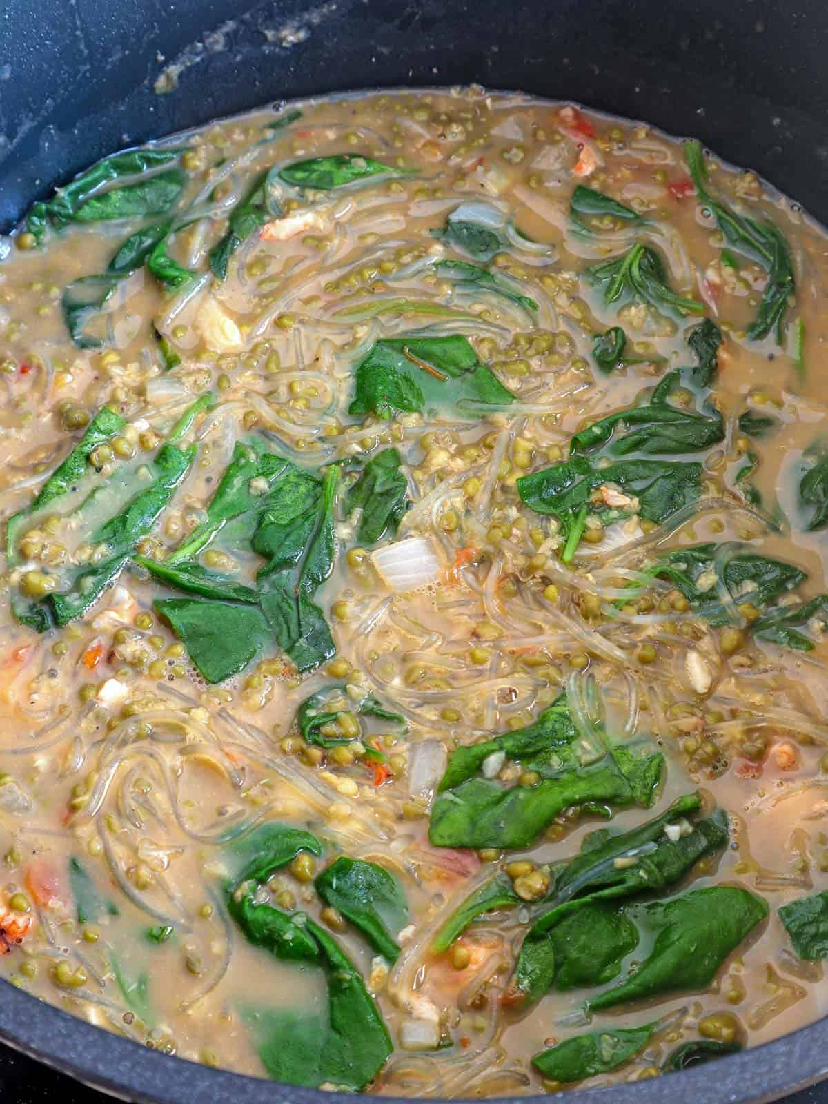 Ginisang Munggo with shrimp, sotanghon, and spinach in a pot