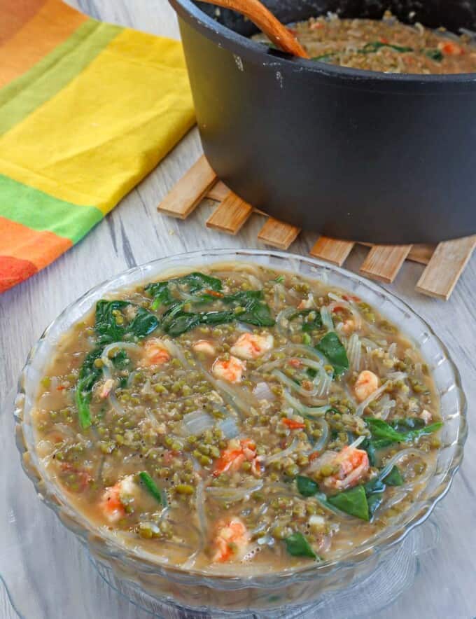 Ginisang Munggo at Sotanghon in a clear glass bowl with a pot of munggo on the side