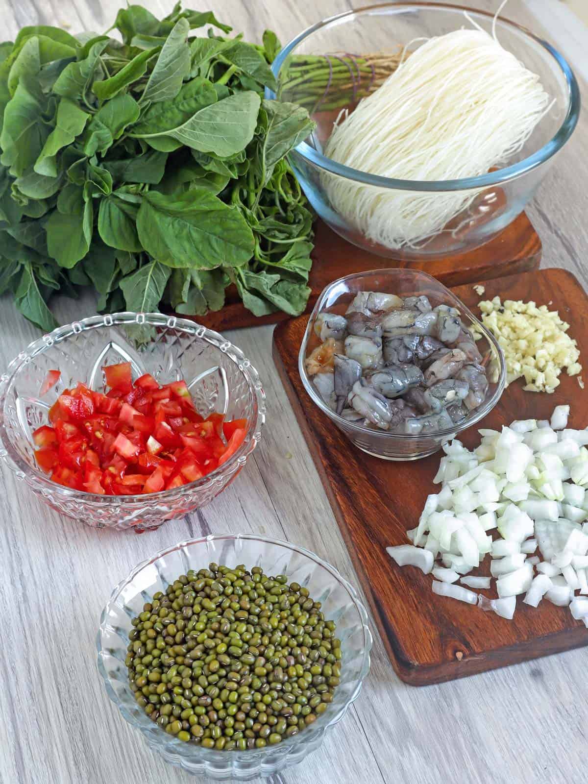 dried munggo beans, chopped tomatoes, onions, garlic, shrimp, sotanghon, and spinach