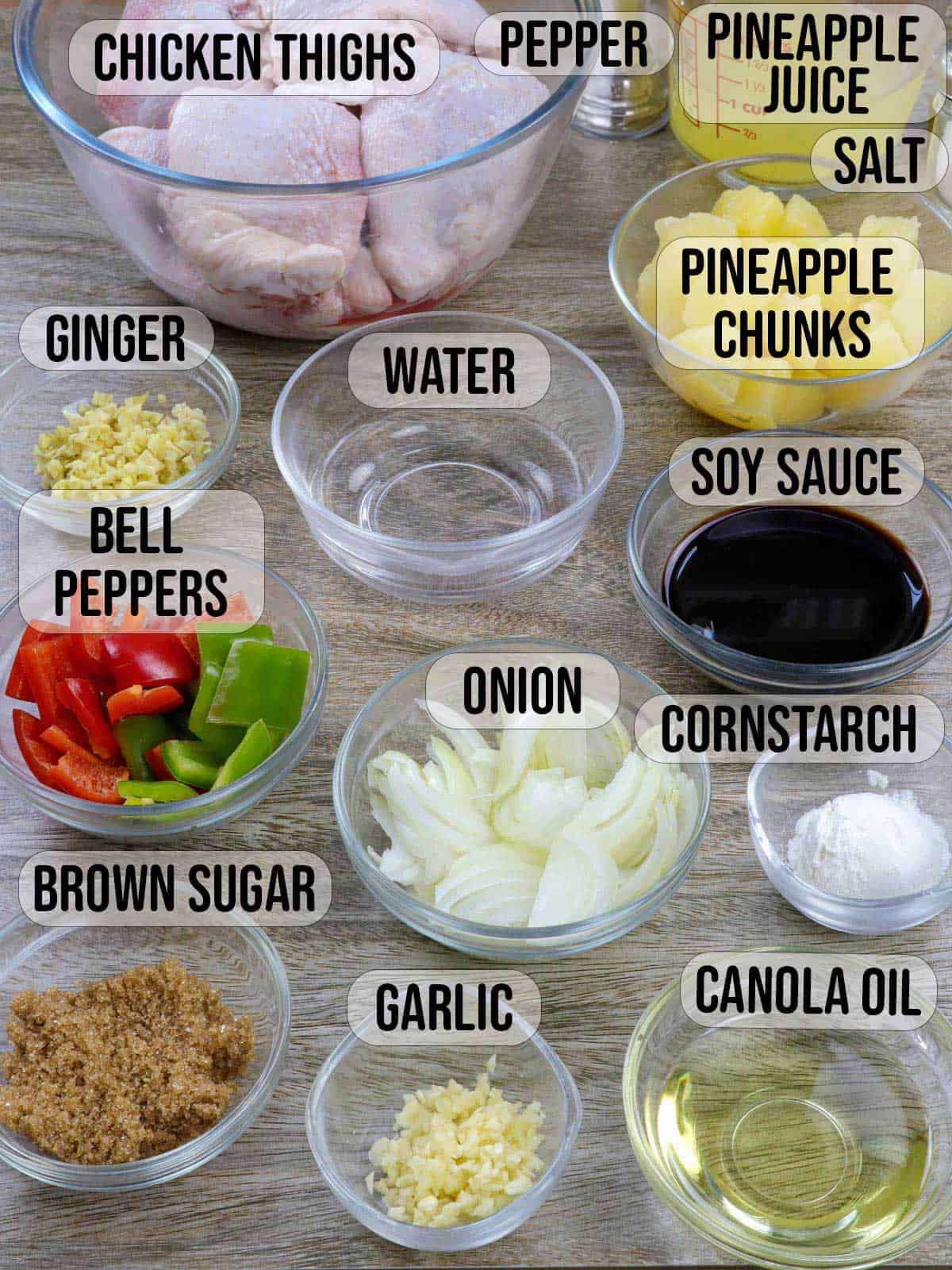 bone-in chicken thighs, water, pineapple chunks, bell peppers, brown sugar, garlic, ginger, onions, soy sauce, cornstarch, oil, salt, pepper, pineapple juice in bowls.