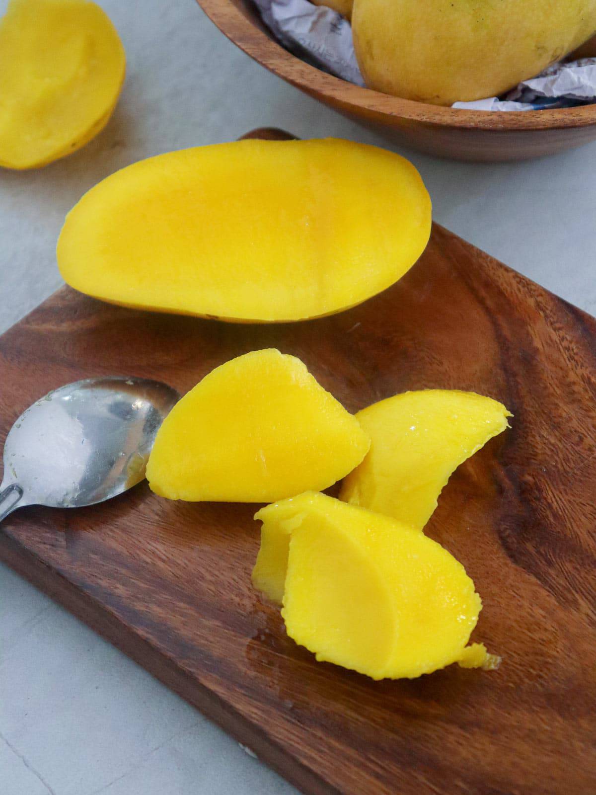 mango pieces on a wooden cutting board