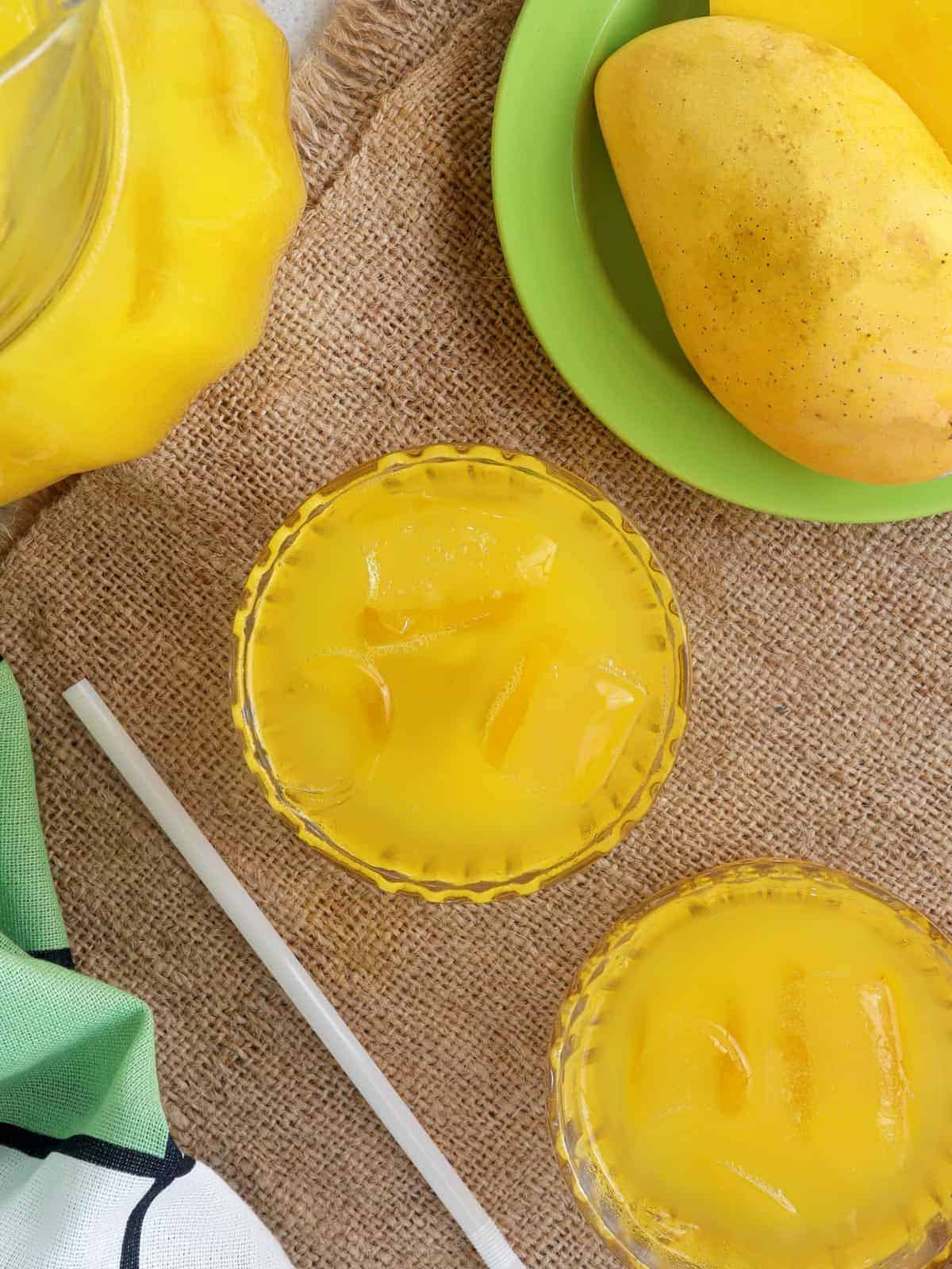 mango nectar in clear glasses with fresh mango fruit on the side