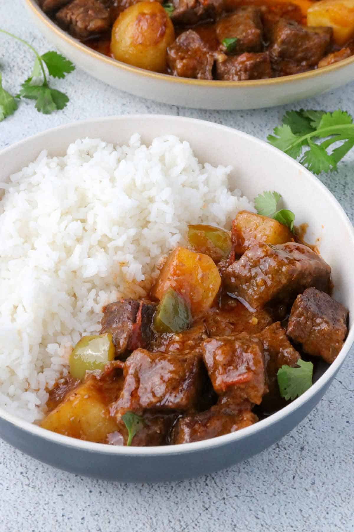 Carne Guisada with steamed rice in a bowl.
