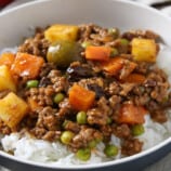 Filipino picadillo served over steamed rice on a plate