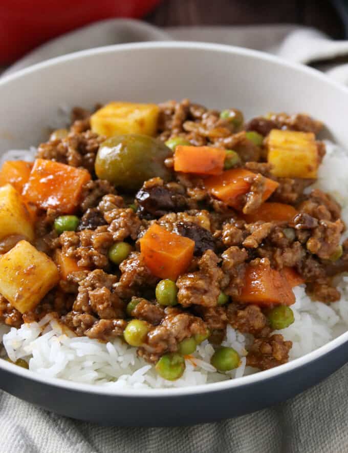 Filipino picadillo served over steamed rice on a plate