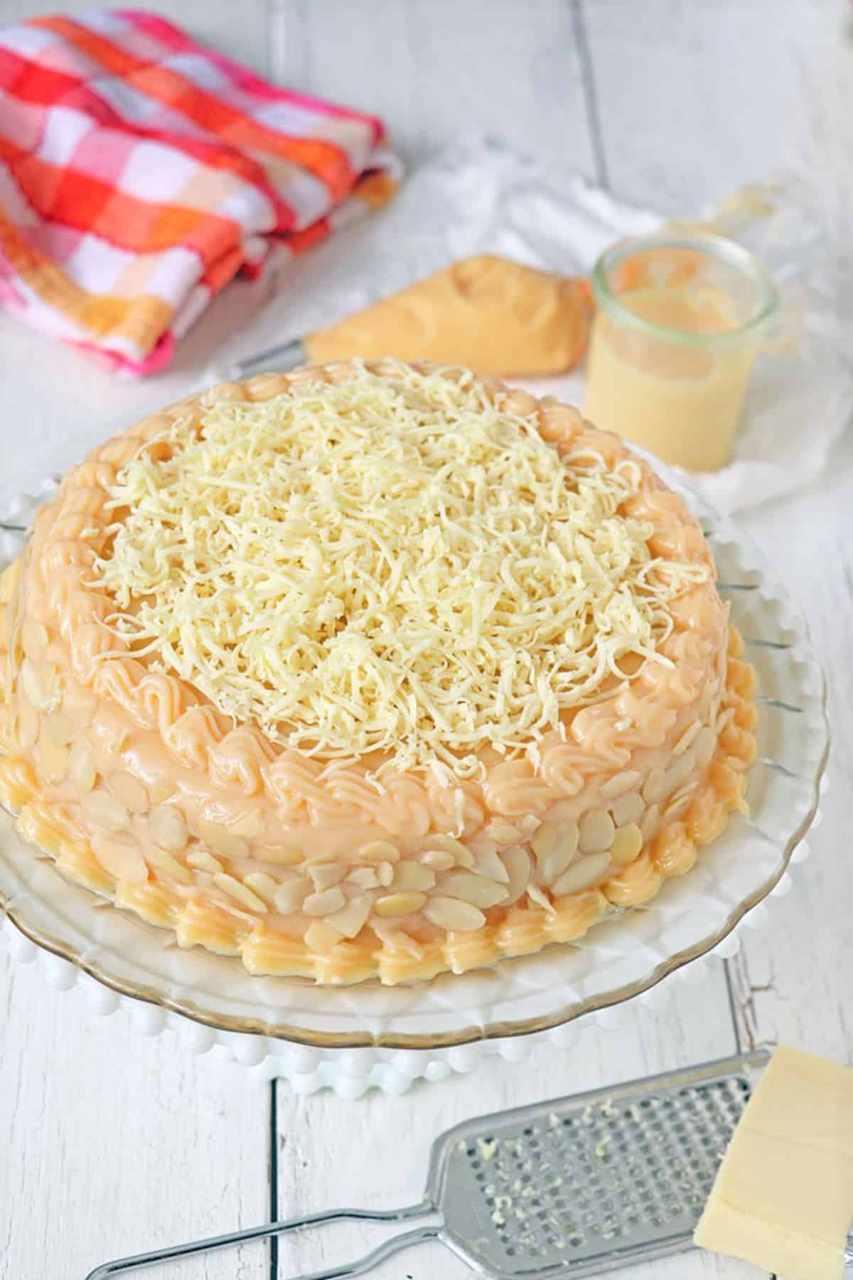 Yema cake made of sponge cake, yema spread, and grated cheese on a serving platter