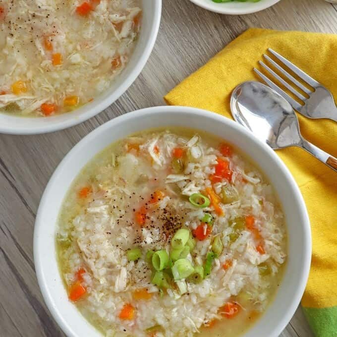 top view of Chicken Rice Congee with green onions in white bowls