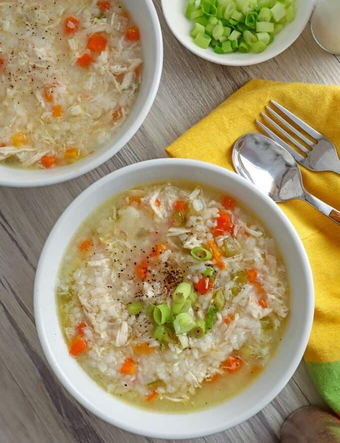 top view of Chicken Rice Congee with green onions in white bowls