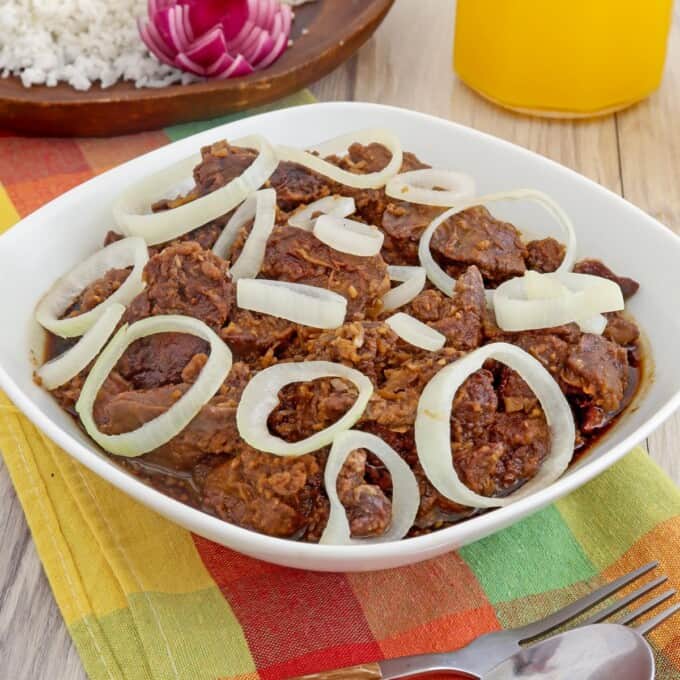 Crispy Chicken Livers a la Bistek topped with onions in a white bowl