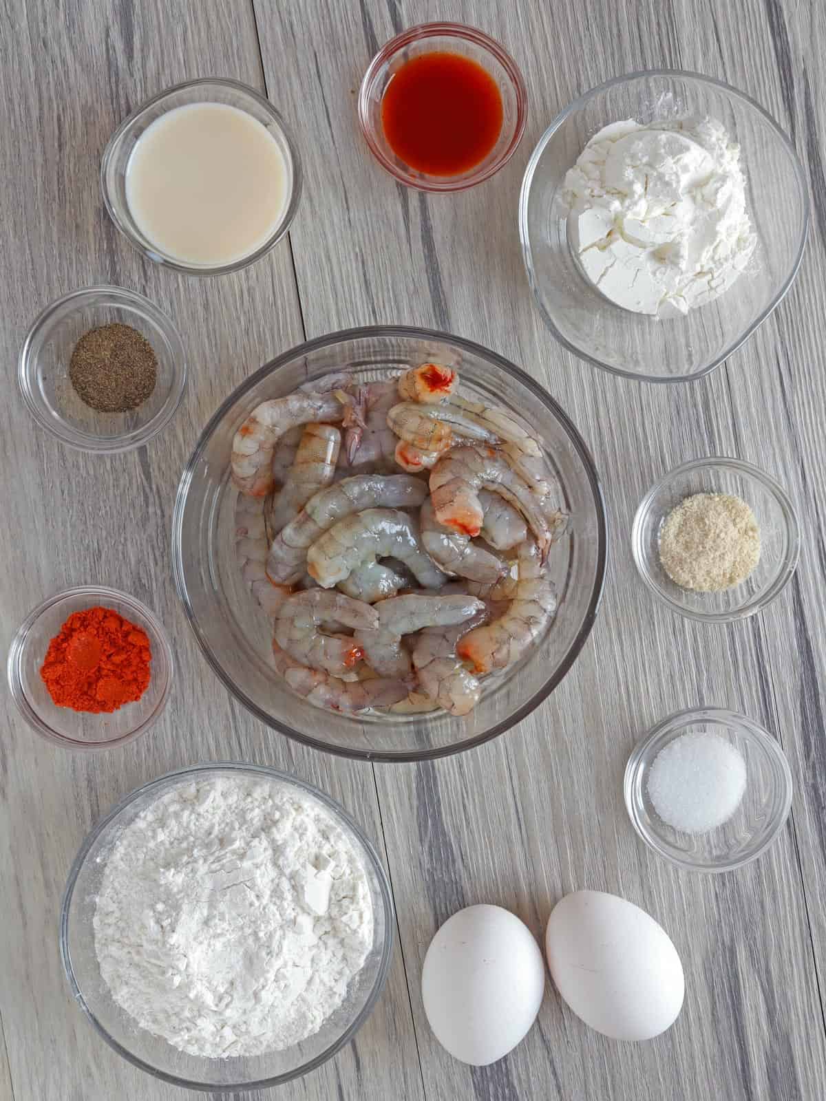 peeled shrimp, cornstarch, flour, eggs, seasonings, and milk in individual glass bowls