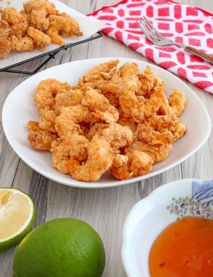 cirspy shrimp in a white serving bowl with a dipping sauce on the side